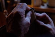 Hands holding a personalized engraved leather wallet under soft lighting.