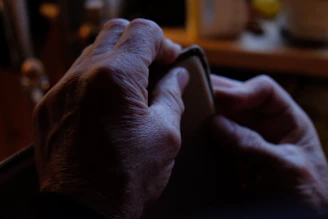 Close-up of hands gently wiping a leather wallet with a soft cloth.
