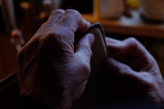 Hands holding a personalized engraved leather wallet under soft lighting.