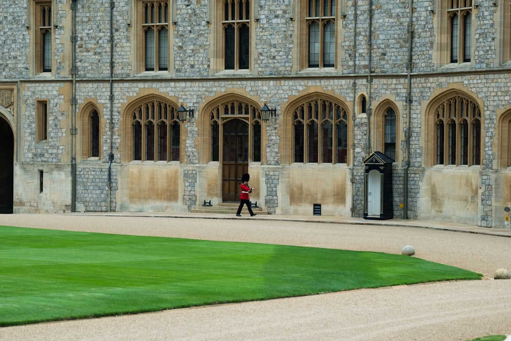 royal guard walking beside concrete building