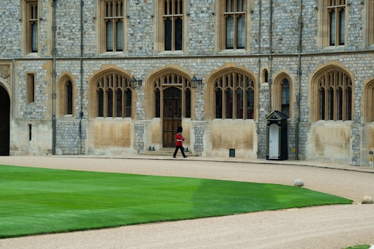 royal guard walking beside concrete building in Windsor Castle United Kingdom