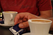 Close-up of a professional reviewing resumes with a cup of coffee nearby.