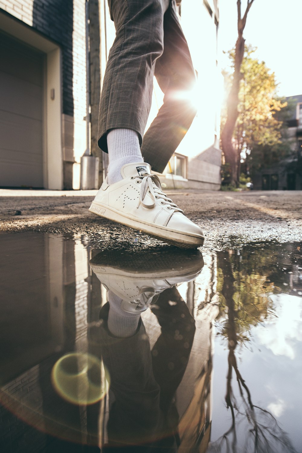 person in black pants and white shoe during daytime