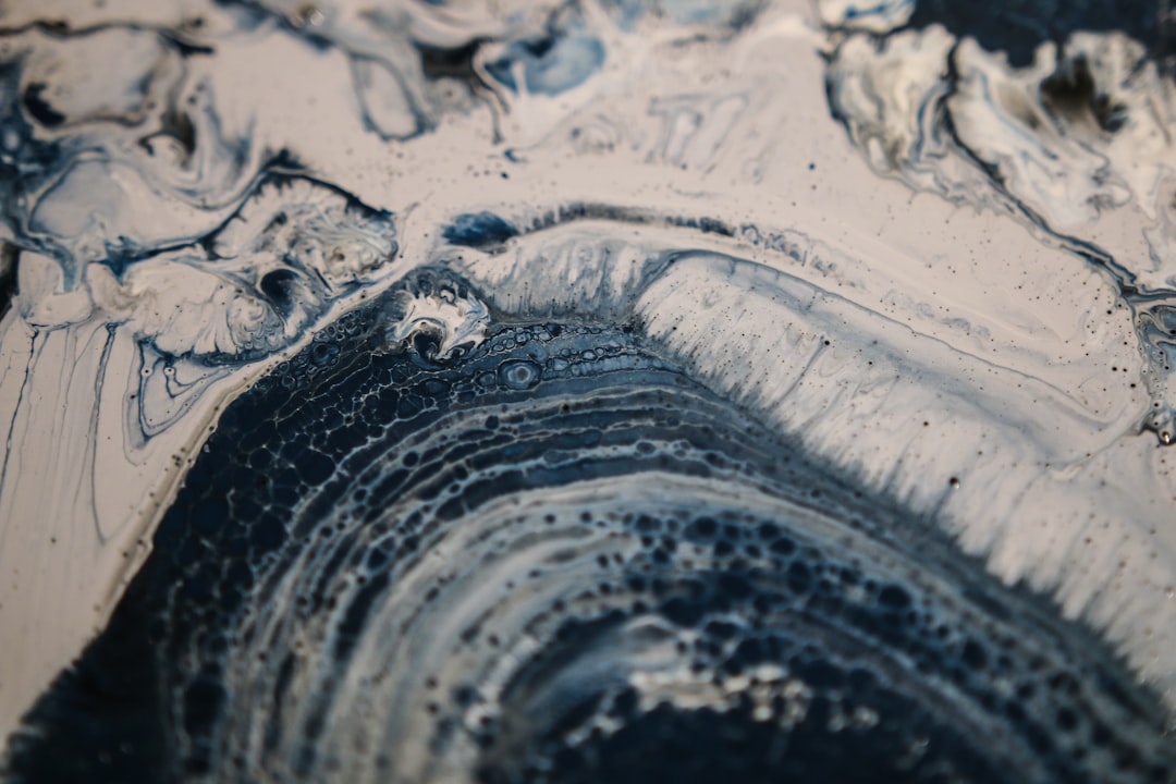This experimental painting features swirls of blue, grey, white, and black paints. As the paints began to dry, I took this closeup.

The technique I use to create this kind of paint texture is called “fluid art,” and it relies on mixing a variety of mediums into acrylic paints to influence how they interact. I’ll use materials like glue, isopropyl alcohol, liquid silicone, and a butane torch.