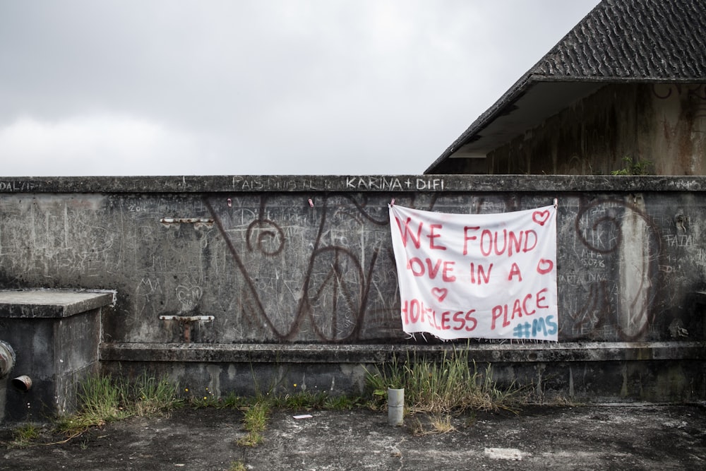 vandalized wall with hanging banner