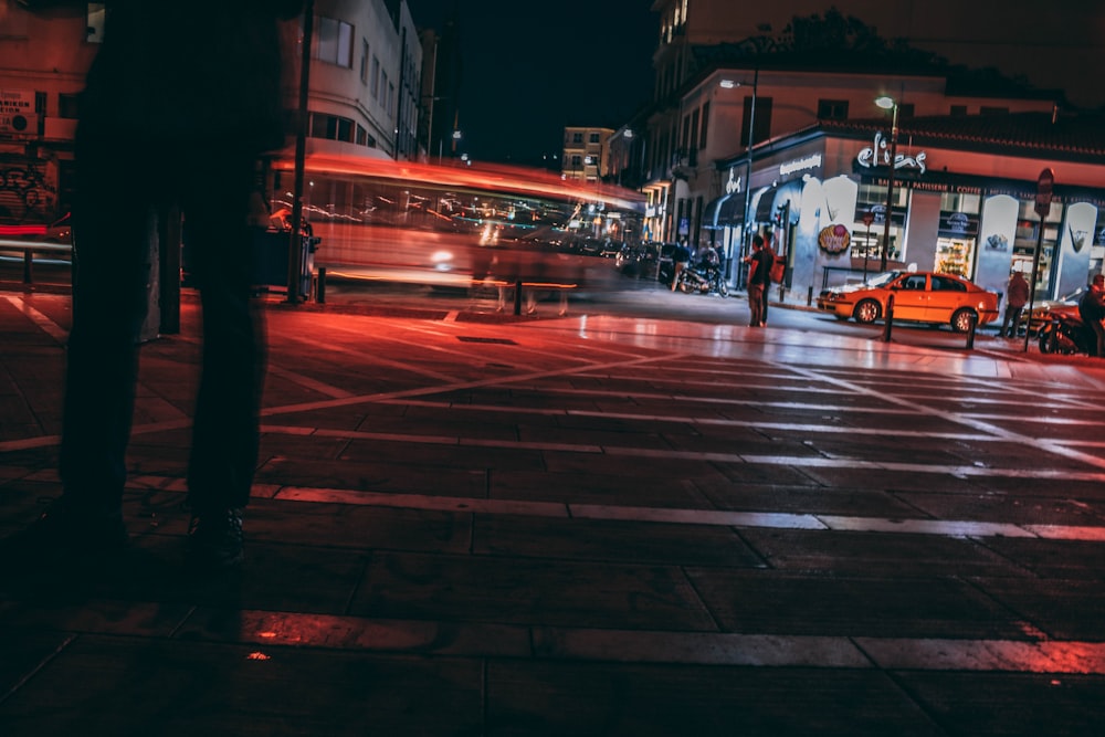 man standing near pedestrian lane at night