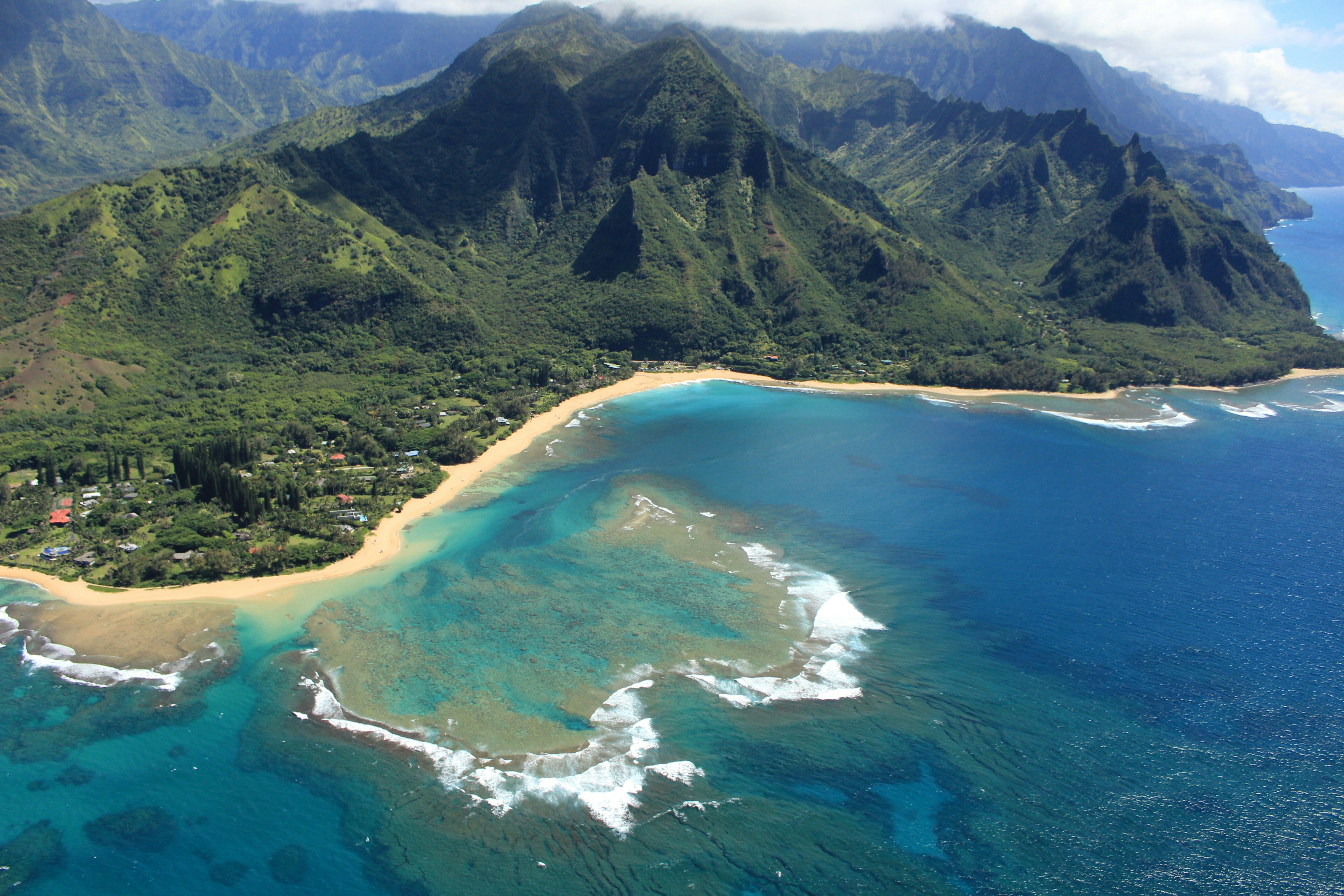 Tropical island adventure scene with lush green mountains meeting turquoise Caribbean sea