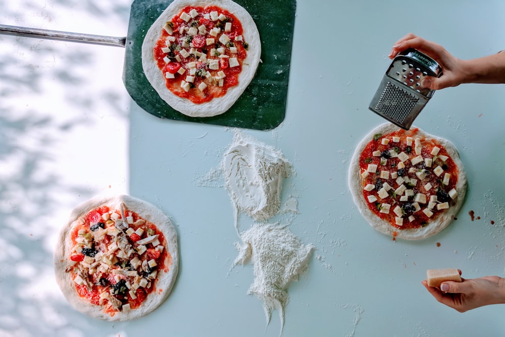 three pizza pie on white surface