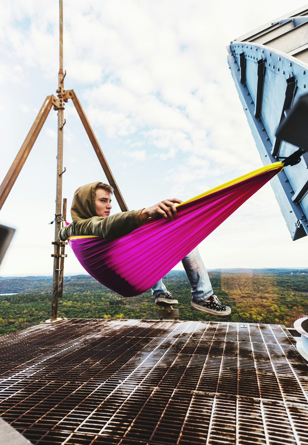 a man sitting in a hammock on top of a building