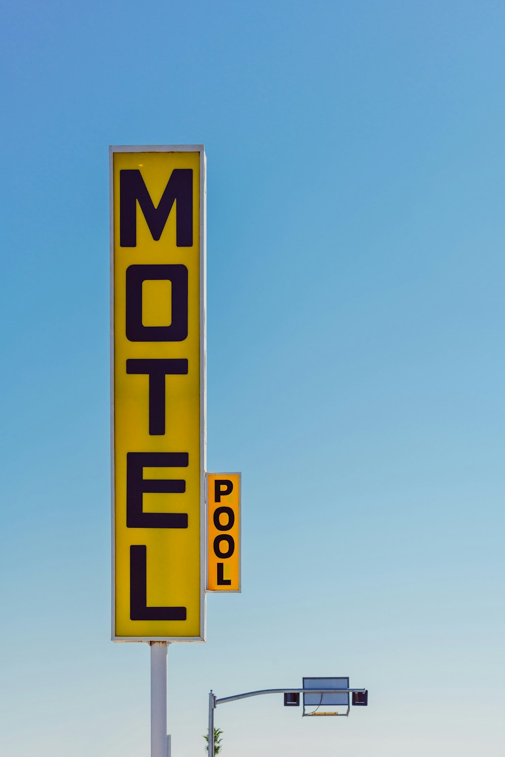 yellow and black Motel signage taken at daytime