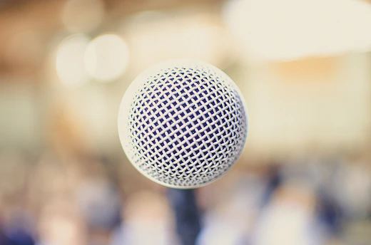 A close-up of a microphone with the New York City skyline softly blurred in the background, capturing the essence of urban storytelling.
