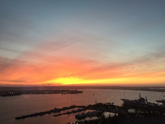 Sunset over Acapulco bay with colorful boats and glowing city lights in the background
