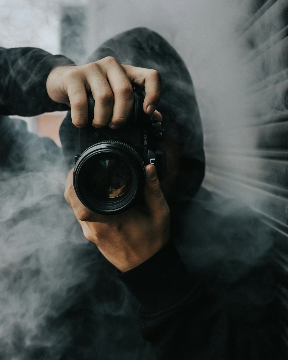 man holding black DSLR camera