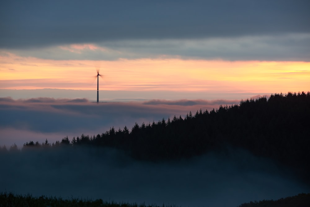 Éolienne entourée de brouillard à l’aube