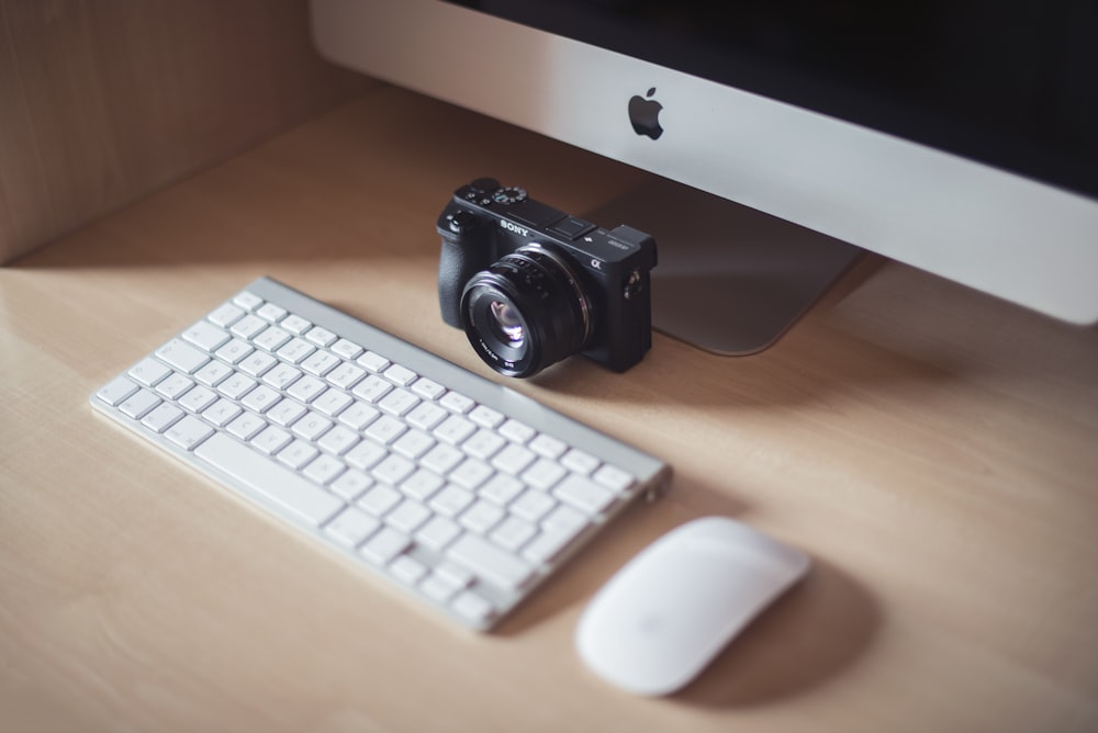 DLSR beside Apple magic keyboard and mouse