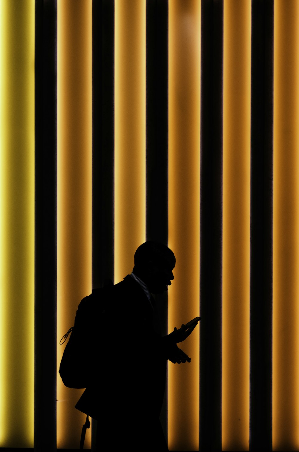 silhouette of man standing on orange and black striped background