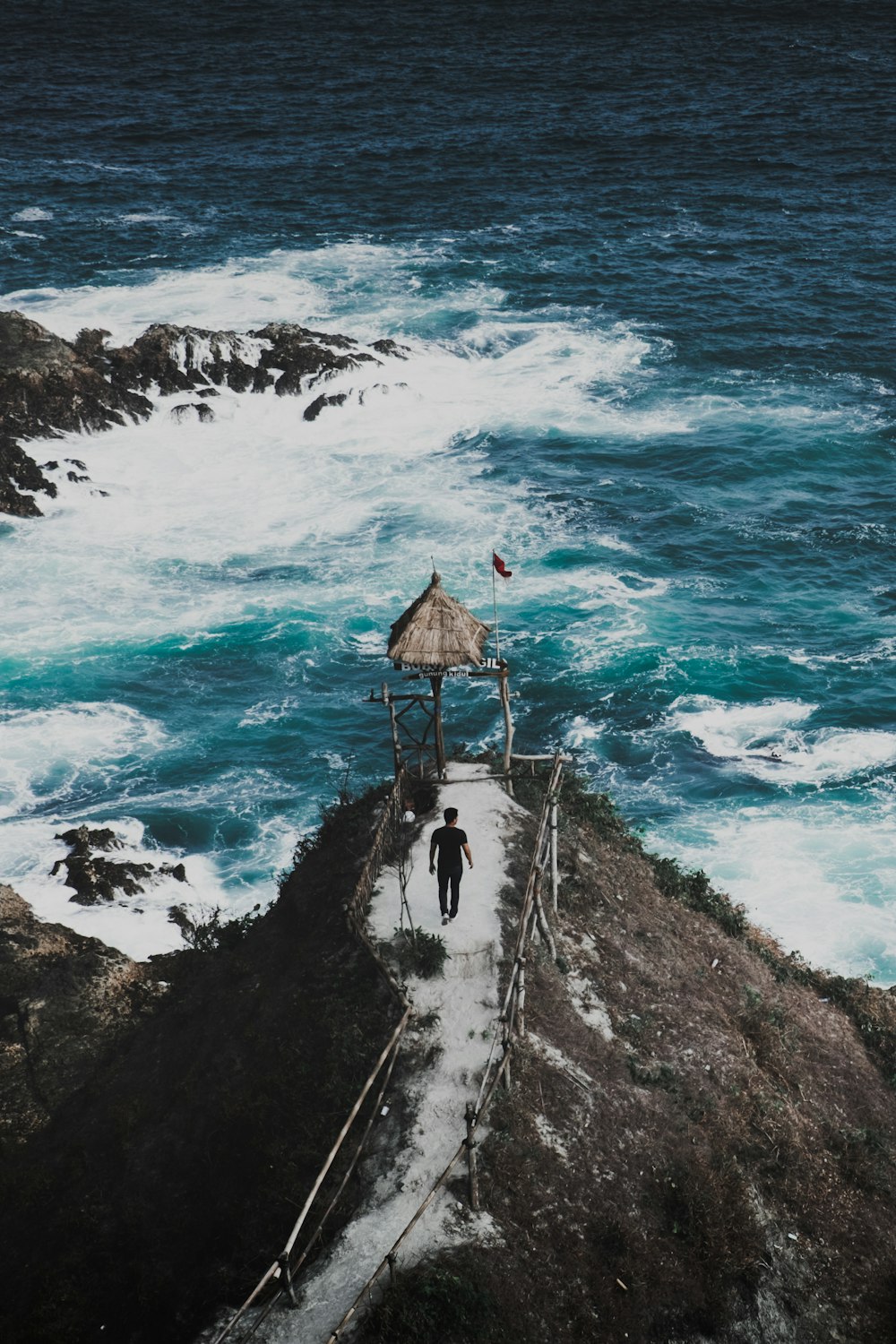 man walking towards the cliff during daytime