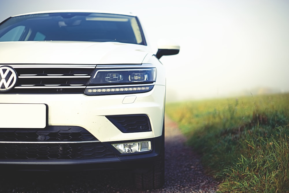 a white volkswagen suv parked on a gravel road