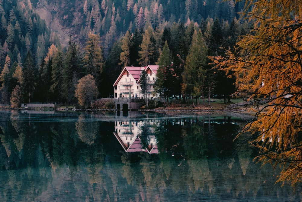 landscape photo of white and red house near lake