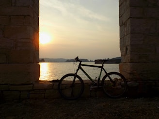 A cyclist enjoying a peaceful moment by a lake during sunset.