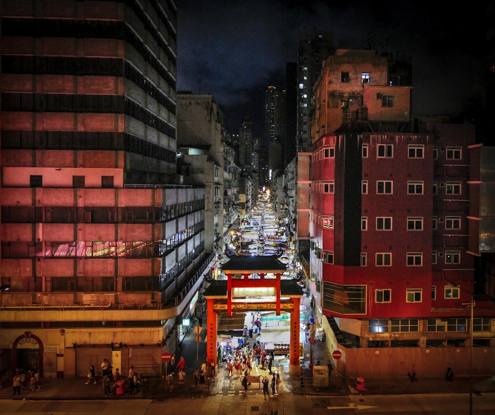 pessoas caminhando entre edifícios à noite