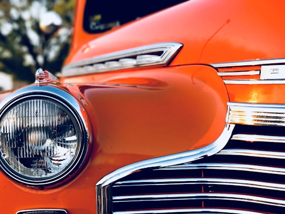 A close-up shot of a rare classic car with polished chrome details reflecting sunlight.