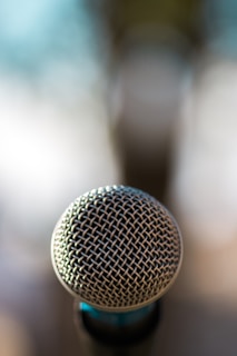 A close-up of a microphone with a city skyline blurred in the background, capturing the essence of urban stories.