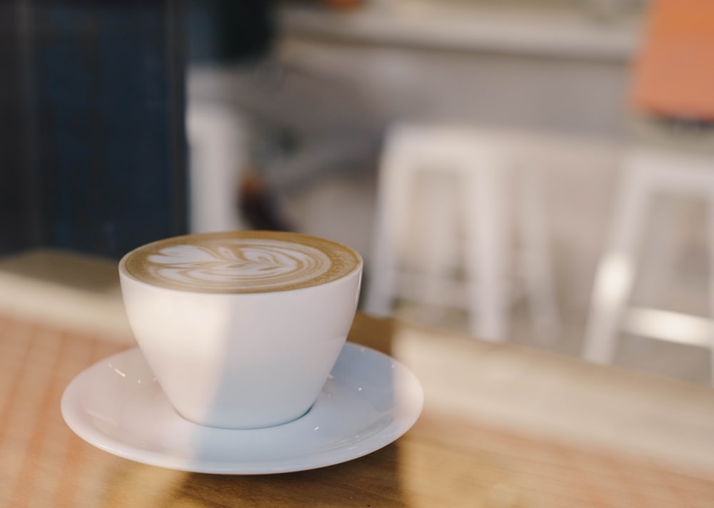 white ceramic mug with coffee in shallow focus lens