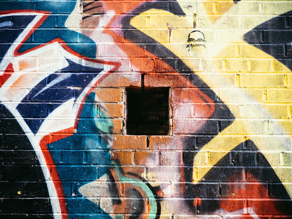 green, brown, and black graffiti artwork on concrete wall