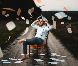 man sitting on chair with book