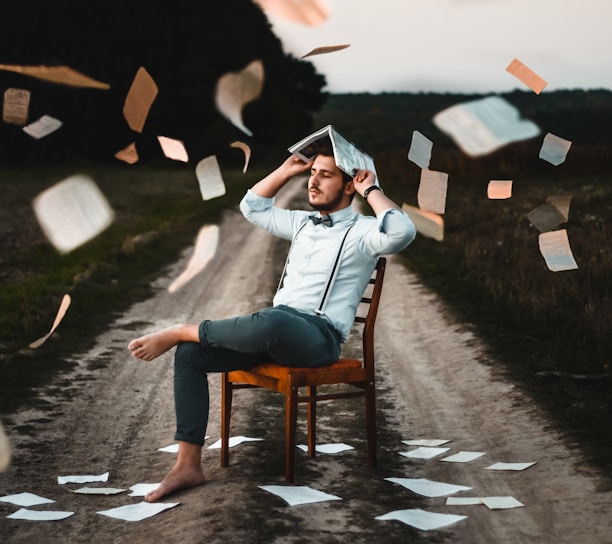 man sitting on chair with book