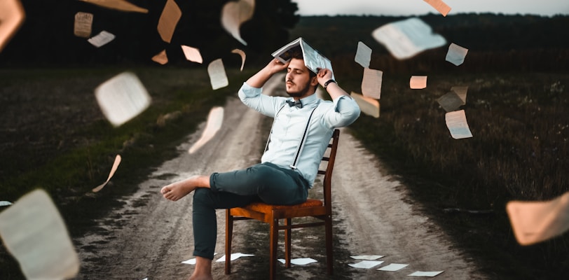 man sitting on chair with book