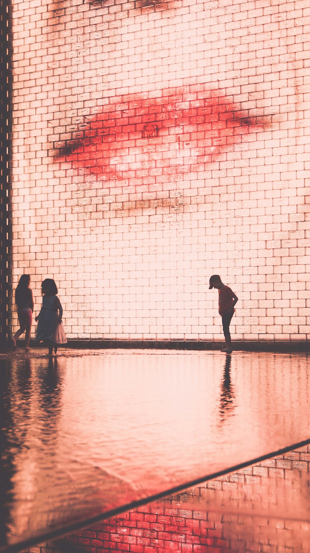 three children standing in front of the wall