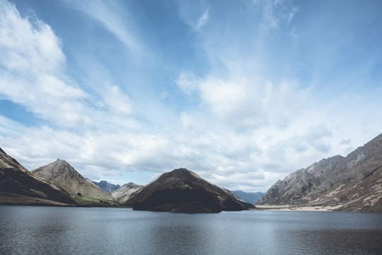 rock formation under blue sky in Moke Lake New Zealand