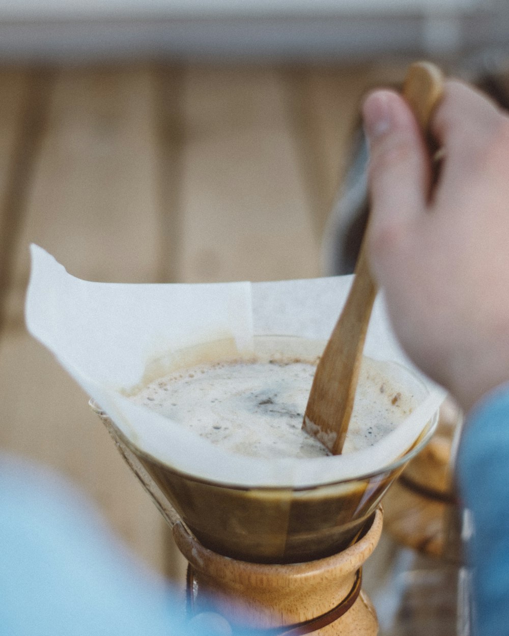 person holding brown wooden spoon