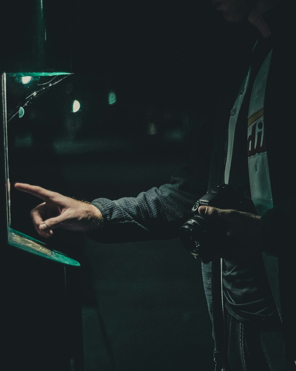 silhouette photography of man holding camera while attempting to operate machine