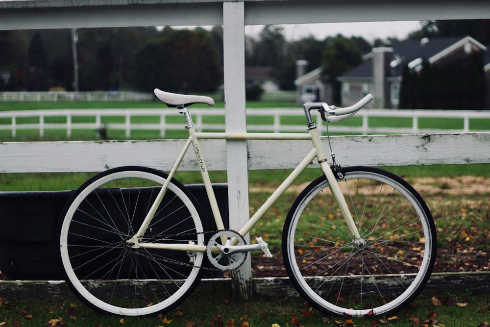 white road bike leaning on white wood plank