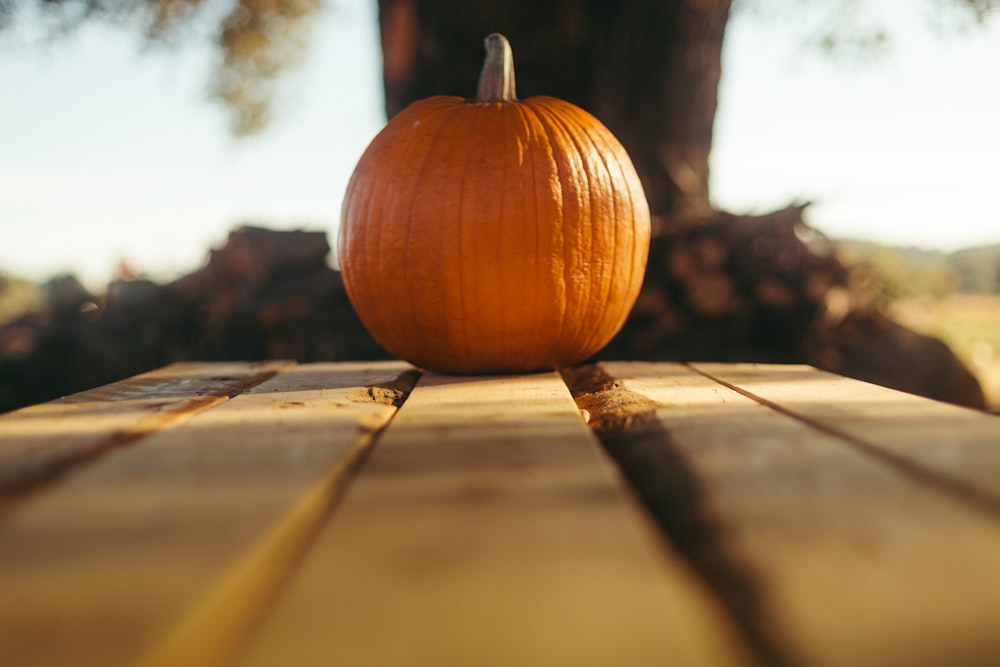 una piccola zucca seduta su un tavolo di legno