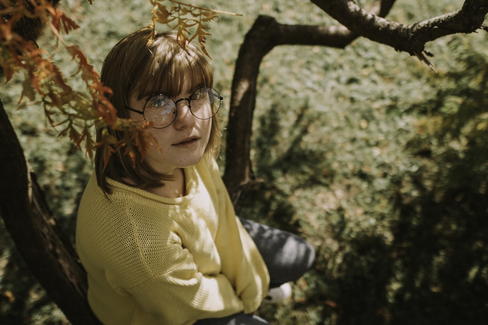 girl sitting on tree during daytime