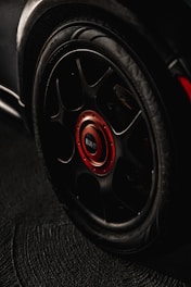 black and red multi-spoke car wheel with tire