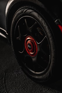 black and red multi-spoke car wheel with tire