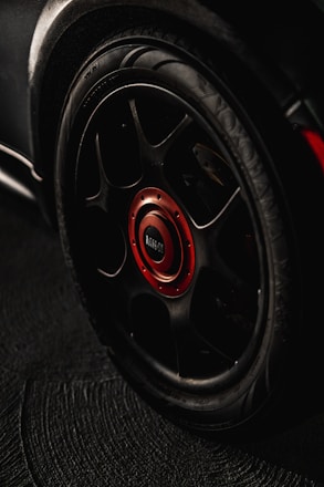 black and red multi-spoke car wheel with tire
