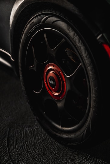 black and red multi-spoke car wheel with tire