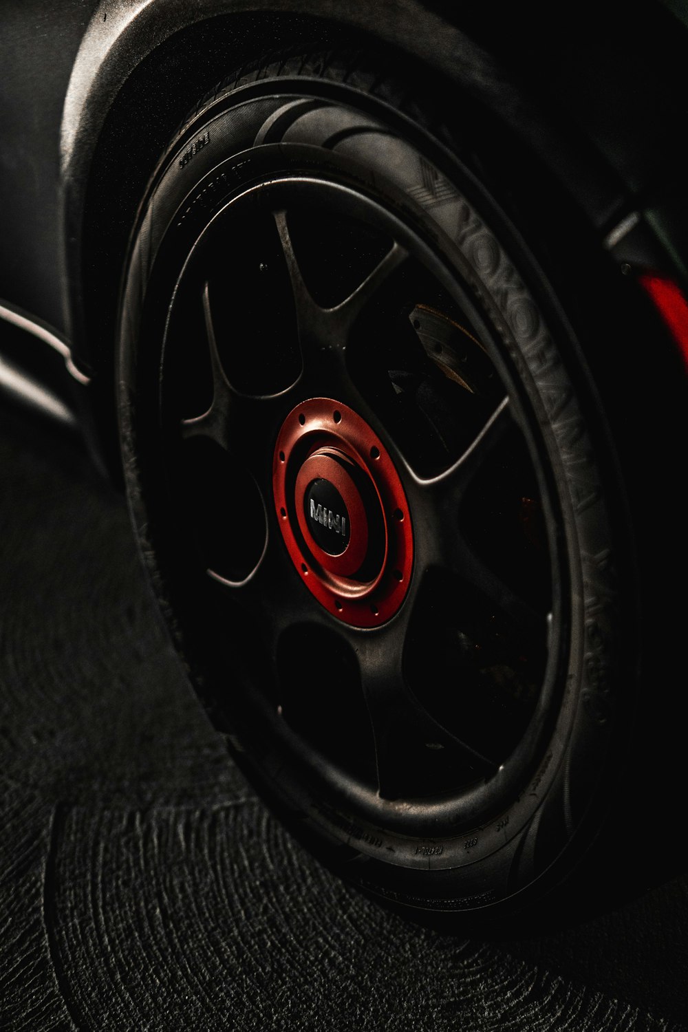 Rueda de coche de radios múltiples negra y roja con neumático