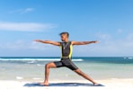 man standing at seashore while yoga