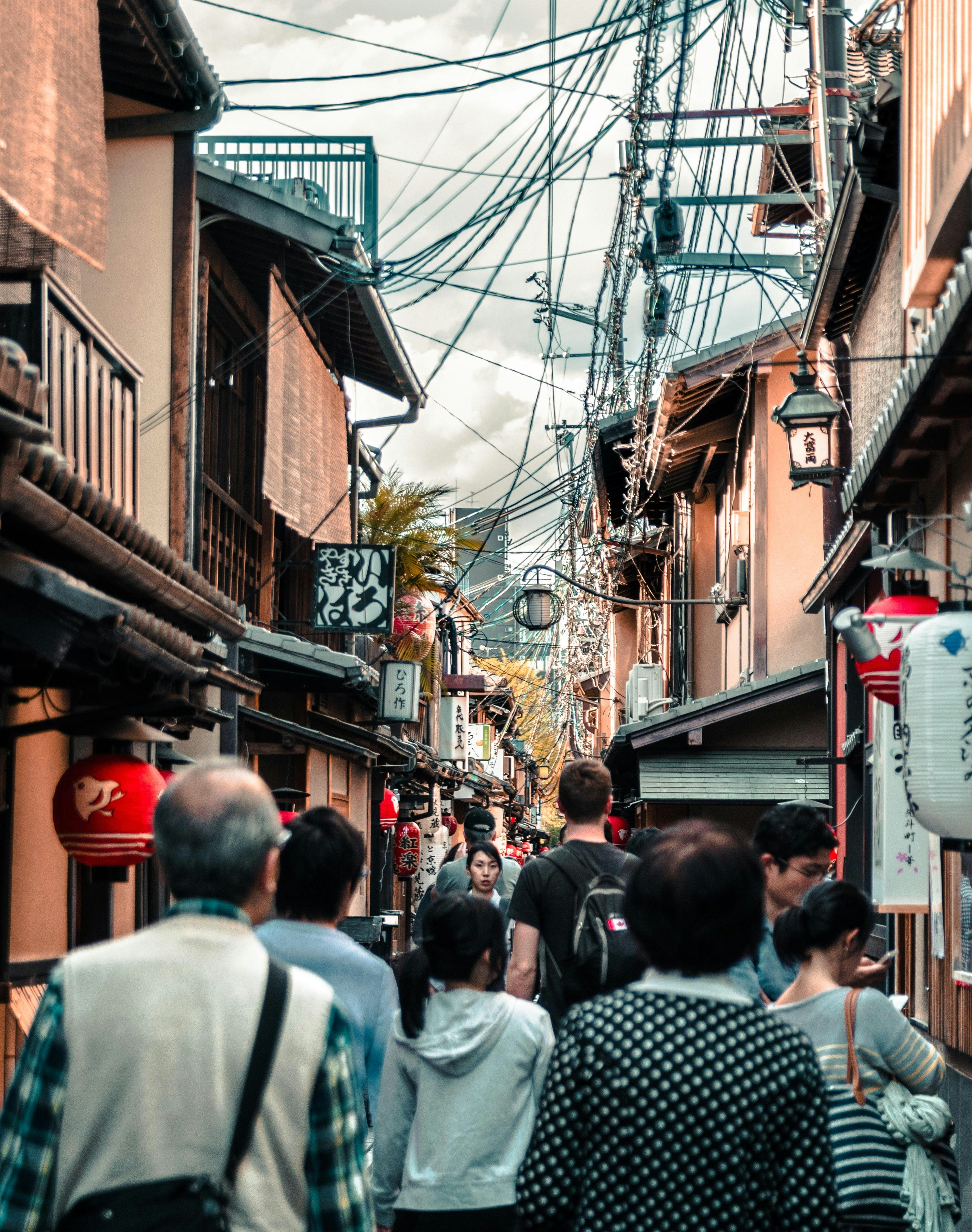 people walking between brown houses