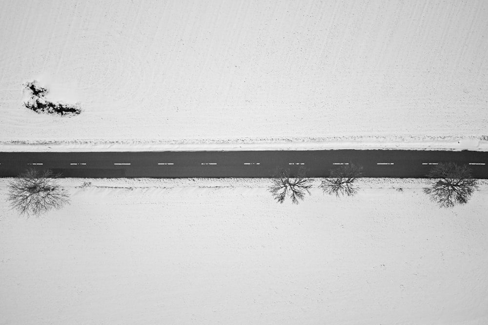 Vista de pájaro de la carretera en medio del campo de nieve