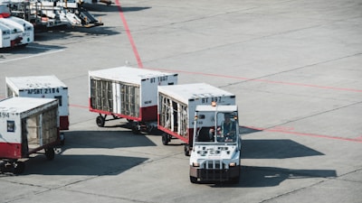 two white-and-red trucks MIAMI AIRPORT DELIVERY