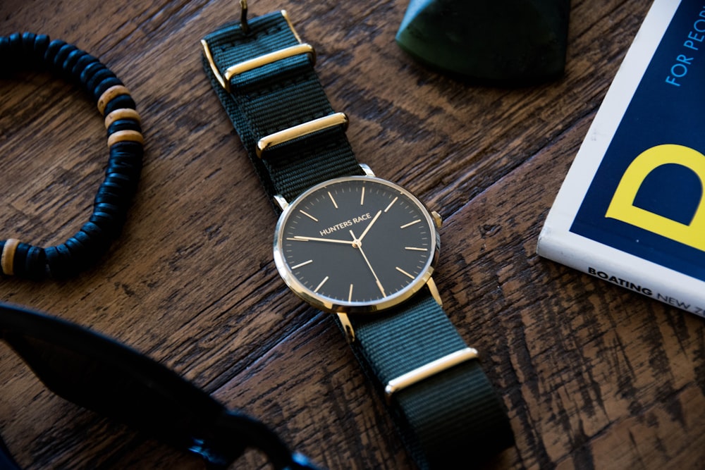 round silver-colored analog watch with black strap