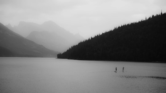 silhouette of hills near body of water at daytime in Waterton Canada